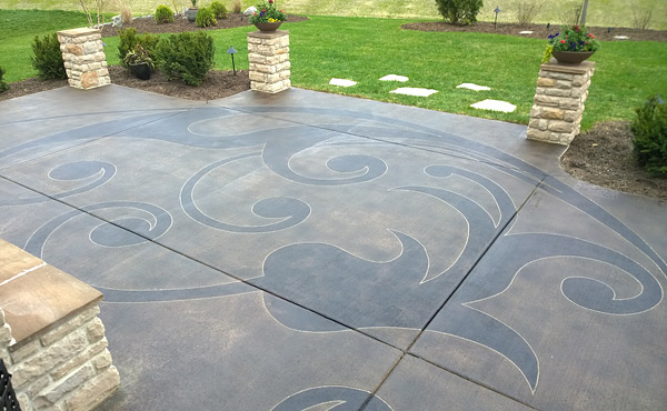 Stained and sealed concrete backyard patio after a saw cut design was placed in the concrete