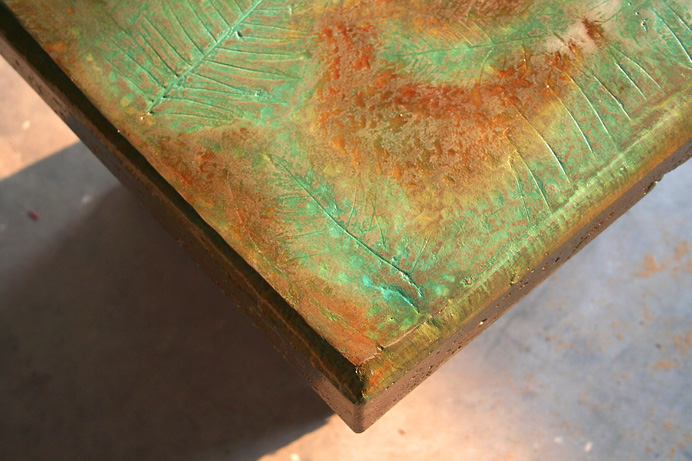 green and brown stained table with leaf imprints