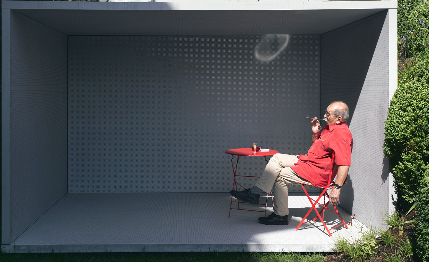 man sitting in a red chair smoking a cigar