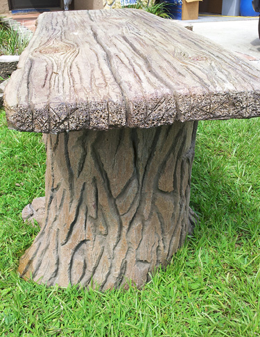 tree looking bench made out of concrete on grass