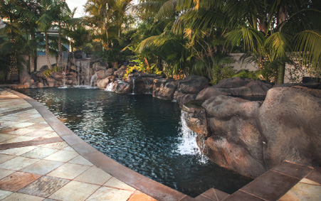 outdoor pool with concrete rock formations and stained floor