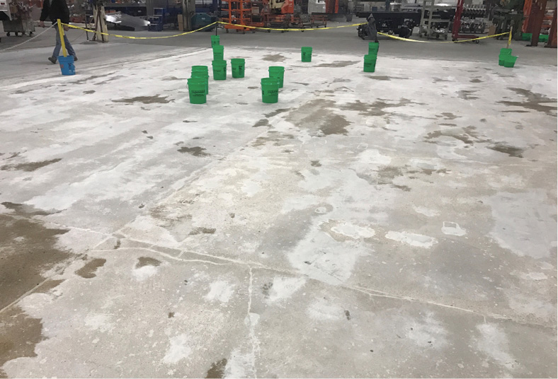 Metal screws can be seen as preparation got underway with diamond grinding of the damaged concrete floor to produce a relatively uniform concrete surface, followed by a considerable amount of patching the concrete defects and damage.