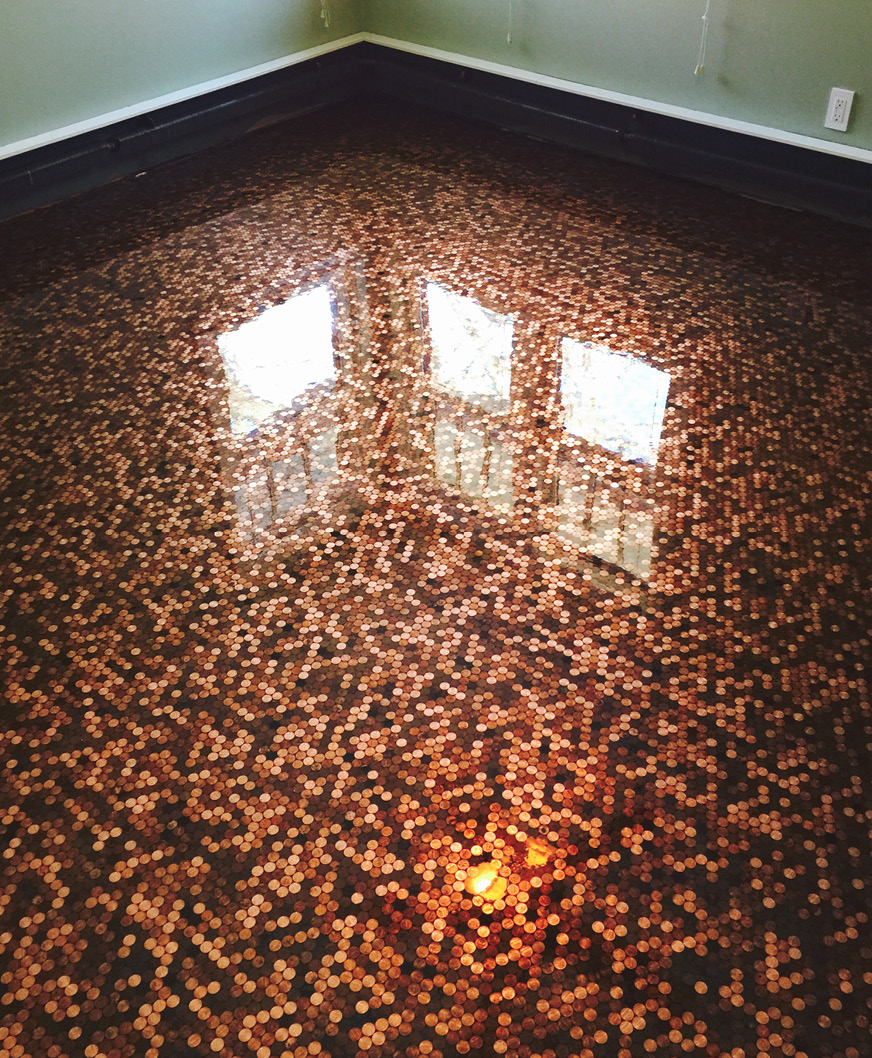 Pigmented epoxy coating applied over a floor covered in pennies.