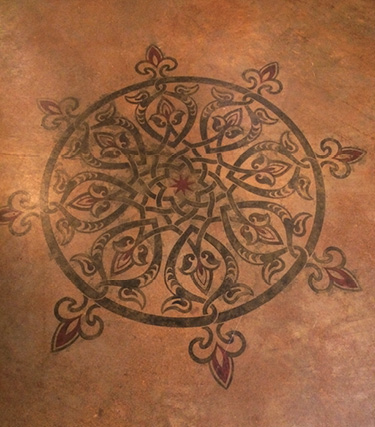 Stenciled medallion on a stained concrete floor.