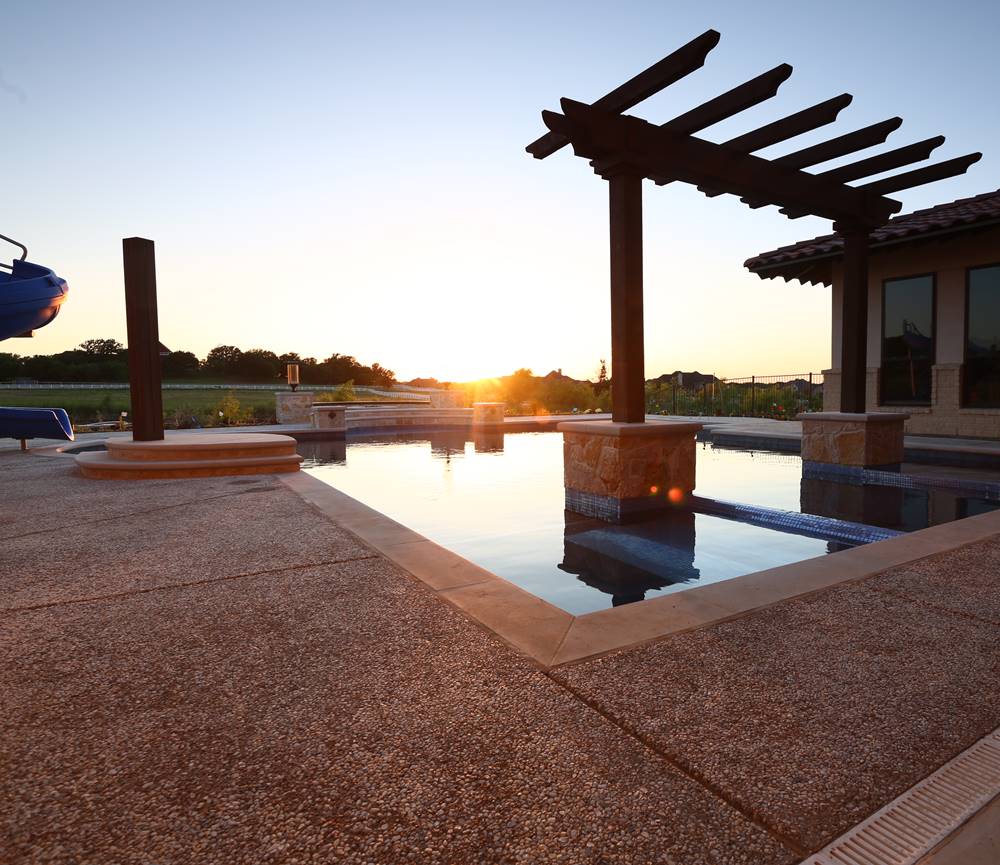 An outdoor pool deck where stones that glow are embedded into the concrete