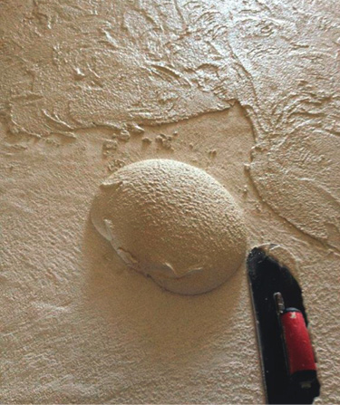 Apply a 1/4 inch-thick carvable limestone texture coat over a scratch coat and then trowel.