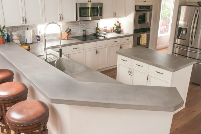 Sleek concrete countertops with a step up eating bar.
