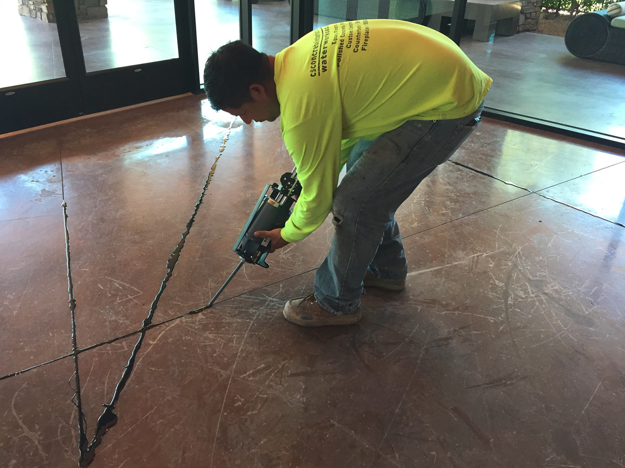 a contractor using joint fillers and sealants to fill cracks on a commercial job