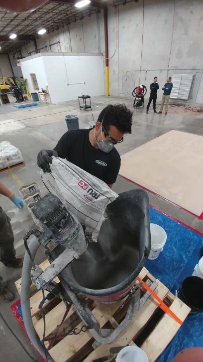 A crew member adds a self-leveling overlayment to a high-speed stand mixer.