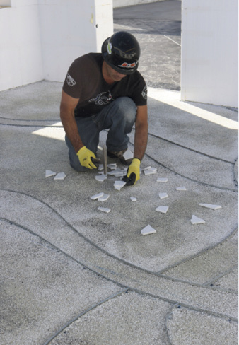 Miguel Lopez places glass into the flooring at Concrete Decor's Decorative Concrete Live at World of Concrete 2018.