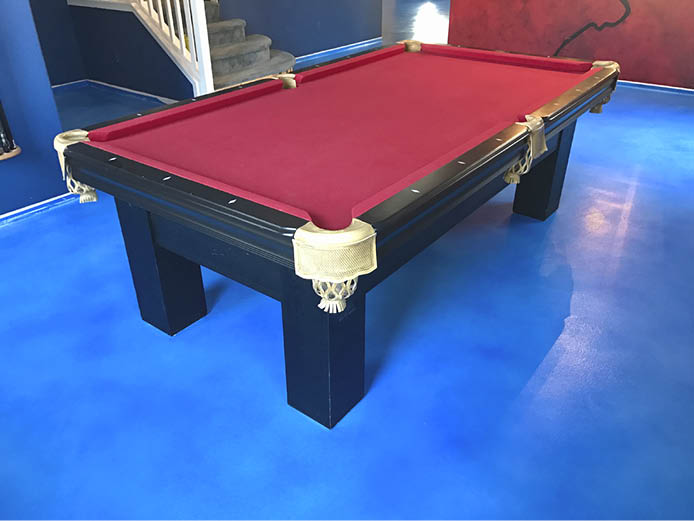 Brilliant blue concrete floor under a red felt billiard table.