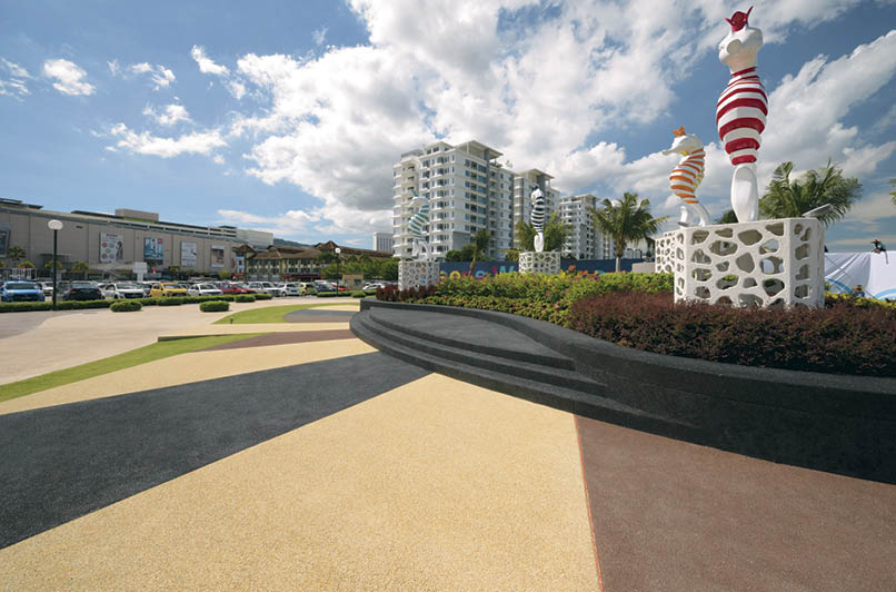Integrally colored exposed aggregate and textured concrete deck out the entrance of the Queensbay development in Penang, Malaysia. Photo courtesy of Bomanite Malaysia