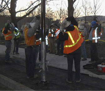 A T.B. Penick crew performs its stretch-and-flex exercises to loosen up before starting the days work at Myriad Gardens in Oklahoma City. Following this routine, they review safety procedures specific to the task at hand. Webcor also has a similar safety program in place.