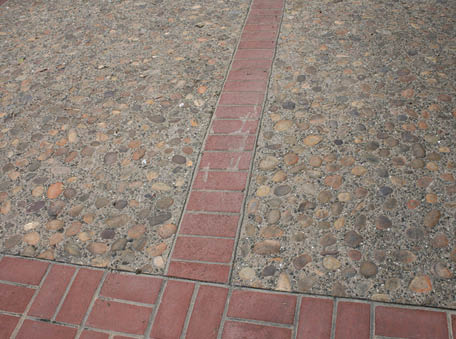 Sunburst cobble aggregate is embedded in integrally colored concrete featuring Sequoia Sand from Davis Colors. Brick stamping picture frames the aggregate. Photo courtesy of Tom Ralston Concrete