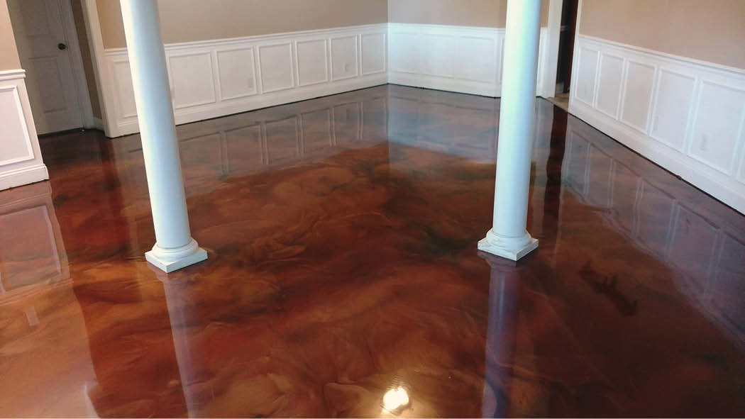 Red and black swirls on a concrete floor in epoxy.