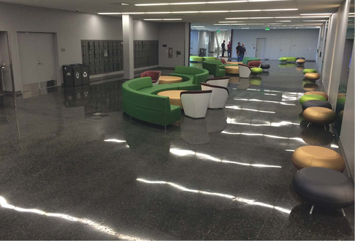 Concrete waiting room that has a highly reflective floor.