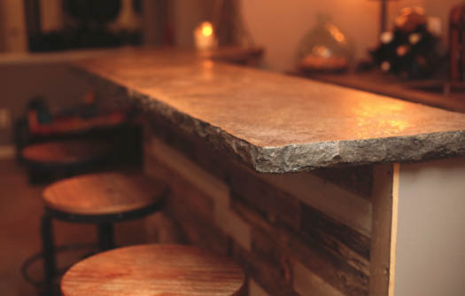 A concrete countertop bartop with a rock looking edge.