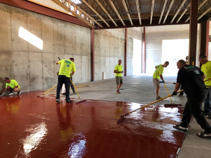 Installers placing urethane cement flooring
