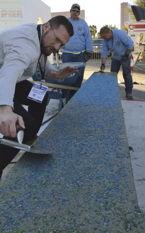 Dustin Thornley of American Specialty Glass places glass aggregate into the sitting bench at the World of Concrete 2019.