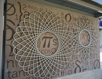 Stenciled concrete wall with a geometric circular pattern attached to it.