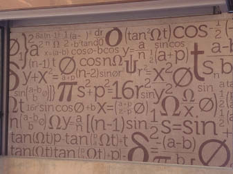 Mathematic equations that have been stenciled onto a wall in a metro station.