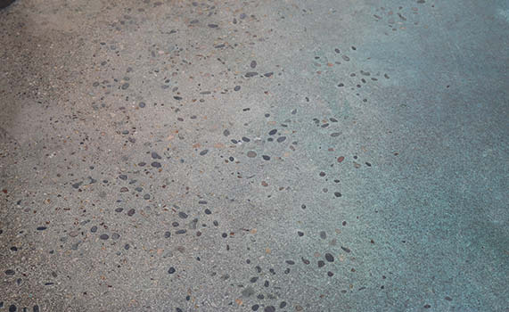 Polished concrete complete with exposed aggregate and blue dye.
