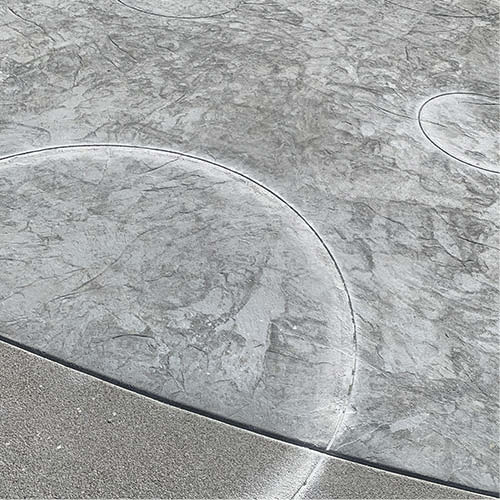 A circle design was implemented on the concrete courtyard using an engraving machine and concrete stains.