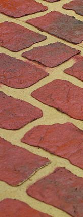 An up close shot of the finished stenciled concrete with grout lines of different color than the face of the faux brick.