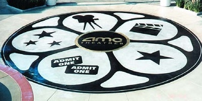 Finished theater movie reel at the AMC theater using a concrete sandblasting stencil over white concrete.