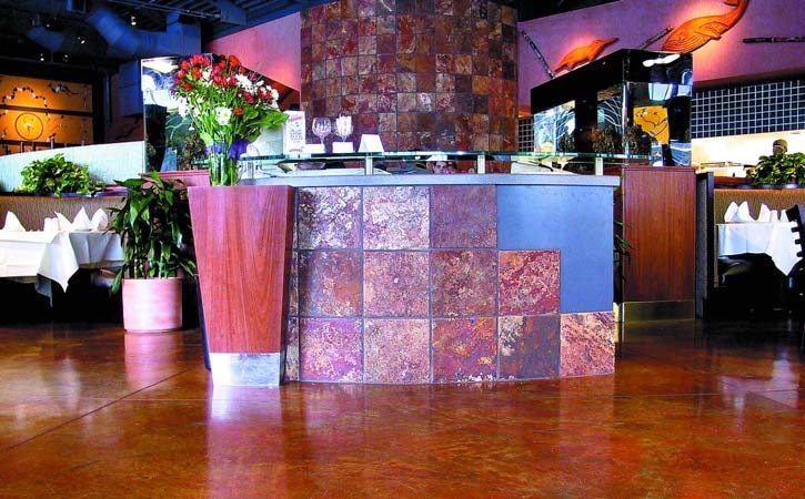 Concrete overlay in a high traffic restaurant in burnt orange. Honor expansion joints throughout the process. For saw-cut control joints, you can self-level over them, but map them in and make saw cuts in the topping to mirror them,