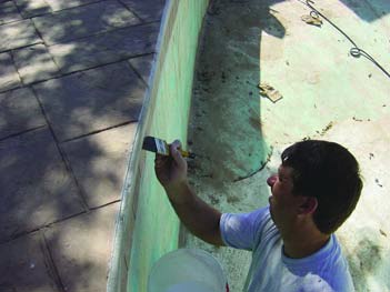 Applying color to concrete with a chip brush.
