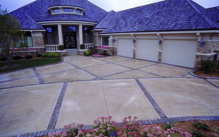 An oversized driveway is broken up with various squares creating dynamic visual effects.