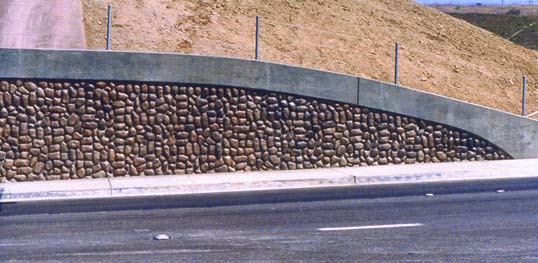 Decorative concrete along the side of a highway brings color and texture to an otherwise boring hillside.