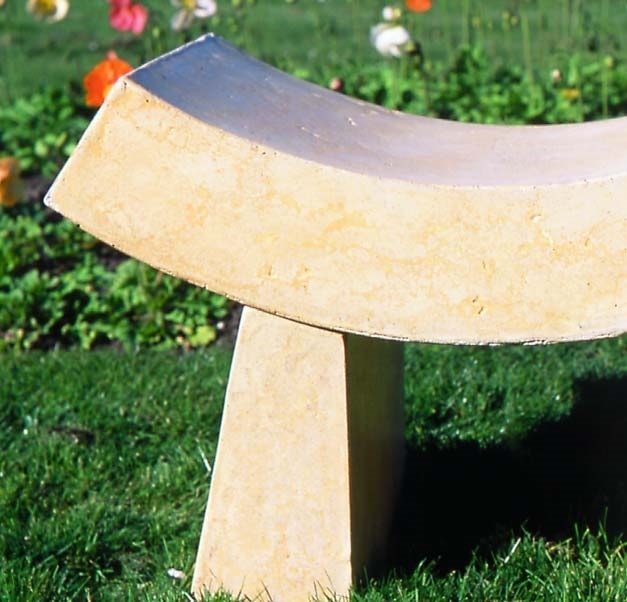 Close up of a tan colored concrete bench by Buddy Rhodes has a Asian inspiration with the curved seating area.