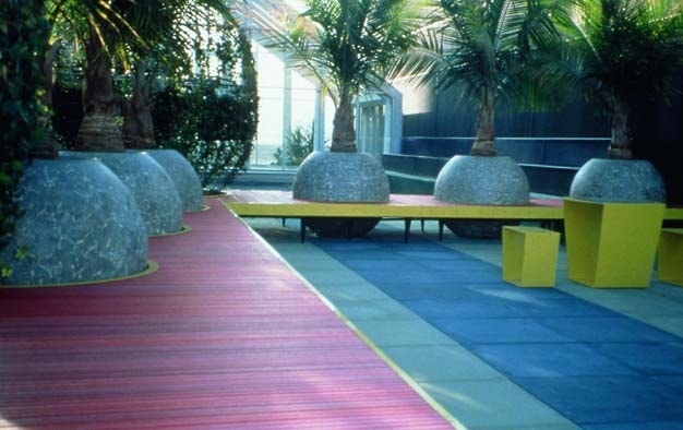 Colorful overlay surface with round, ball shaped planters for the palm trees.