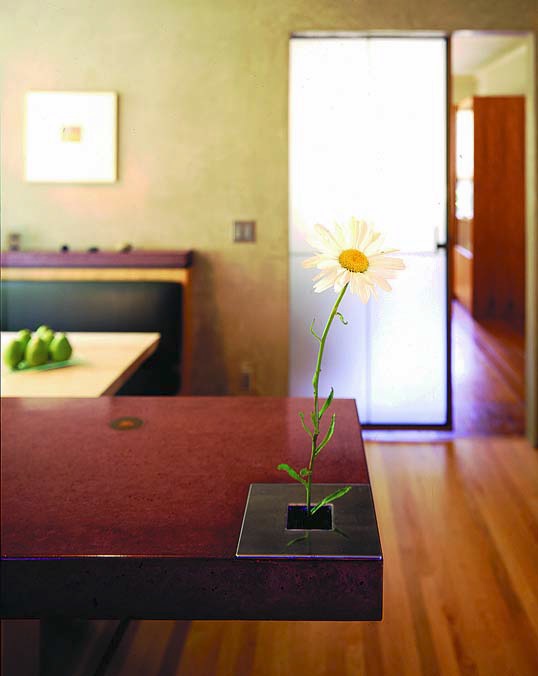 Concrete countertops are limited only by imagination, here a flower pot is built into a concrete desk.