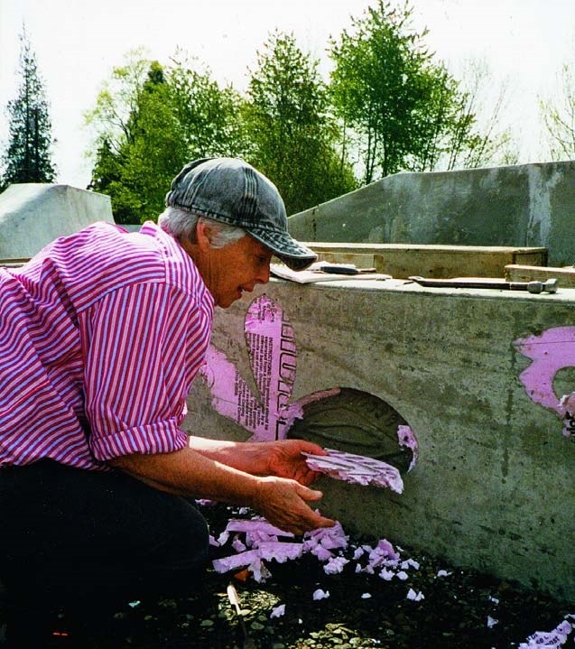 Lilli Anne Rosenberg removing pink foam mold to reveal a skate boarder silhouette in concrete wall.