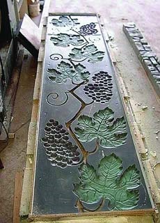 Concrete form liner of grapes and grape leaves on a vine. when used in a concrete form, the grapes will leave an image of the vine on the concrete.