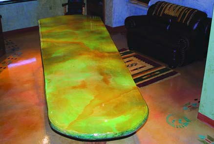 A striking concrete countertop stained with green and orange hues.