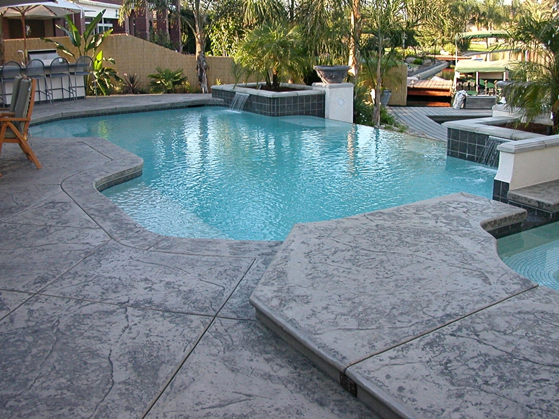 This simple stamped concrete pool deck adds a special touch to any backyard pool.