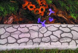 Concrete curbing with texture of individually placed stone and colored grout.