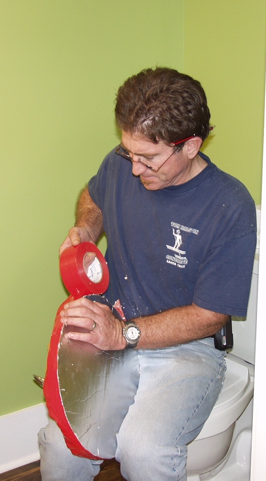 Tom Ralston trims and adheres tape on the jobsite.