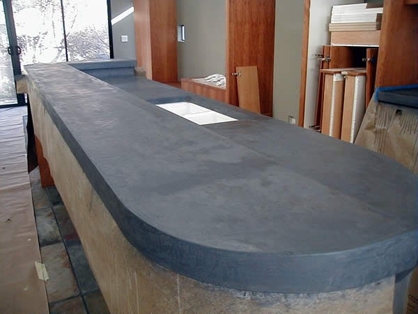 A closer view of a kitchen island with a concrete countertop.