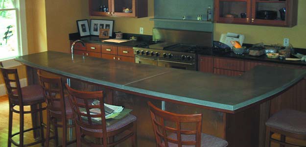 L shaped concrete countertop island in a kitchen where metakaolin was used to harden the concrete.