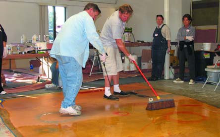 Remove the objects and then spray acid stain on the whole floor, allowing all the colors to mingle with each other.