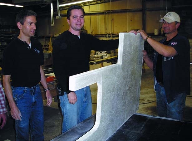 Jeffrey Girard with students standing a precast concrete countertop to inspect the under side at Concrete Countertop Institute.