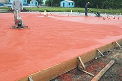 Integral colored concrete power troweling - A power trowel is used to finish integrally colored concrete on a new restaurant floor.