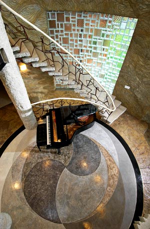 Spectacular Bomanite project surrounding a grand piano near a winding stair case.
