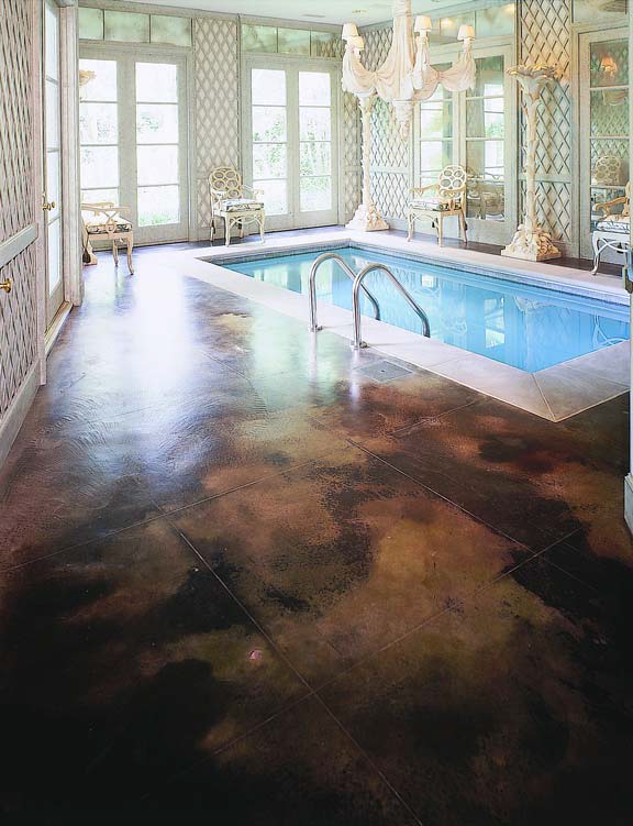 Inviting indoor swimming pool with a concrete deck colored in a rich chocolate brown Kemiko Concrete Product stain.
