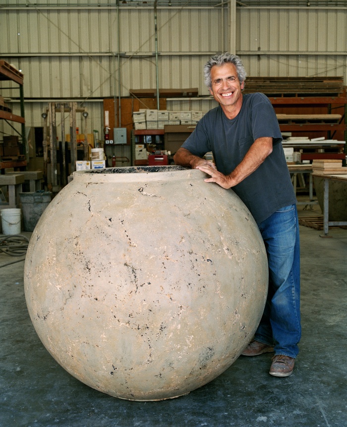 Buddy Rhodes stands next to a 48-inch concrete planter created with one of his molds.
